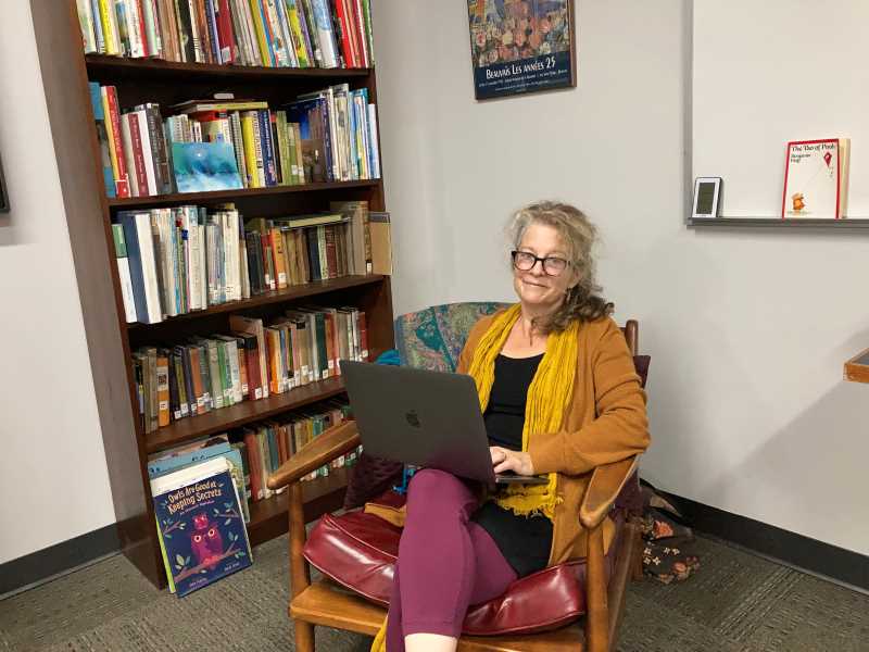 Professor Teri Holford writing in her office in Murphy Library.