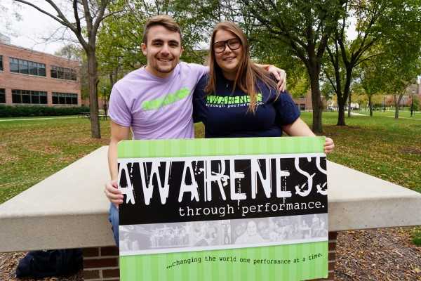 Two Students Holding an Awareness through Performance Sign