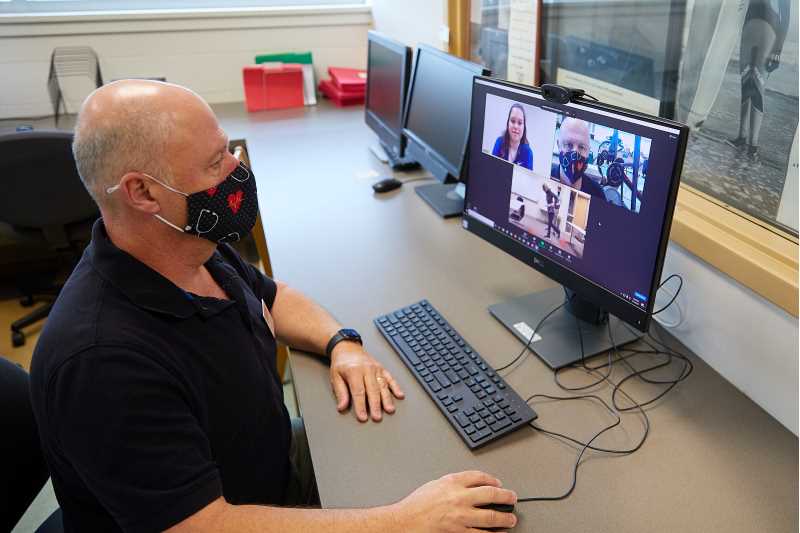 Associate Professor John Greany watches his students provide virtual rehabilitation services to local community members — part of UWL's Exercise Program for Adults with Neurologic Disorders. The assignment gave students firsthand experience within the growing field of telehealth.