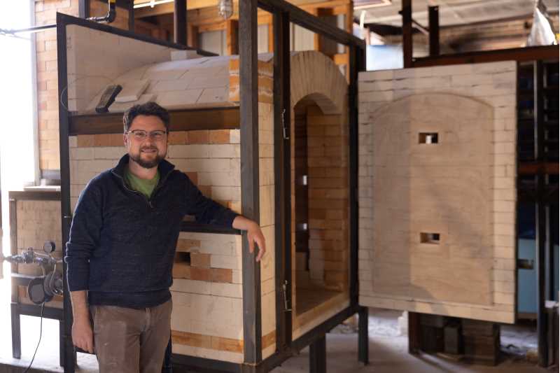 Ceramics Assistant Professor Jarred Pfeiffer with the new kiln that was installed in April, replacing a 20-year-old salt kiln that was unsafe and in complete disrepair.