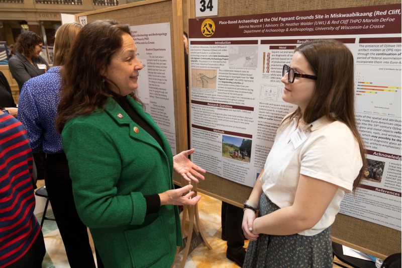 State Rep. Jill Billings talks with UWL senior Sabrina Neurock during Research in the Rotunda Thursday, March 6, in the Wisconsin State Capitol. PHOTO CREDIT: Joe Koshollek