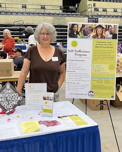 Back to school is for grown-ups too!  Andrea Hansen, standing behind her table displaying educational materials at the La Crosse Center.