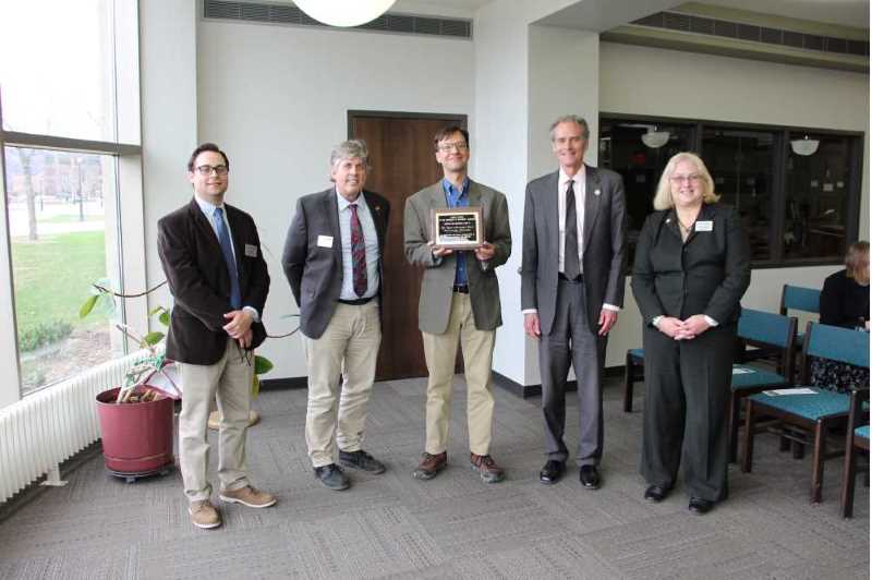 Image of award recipient with library staff