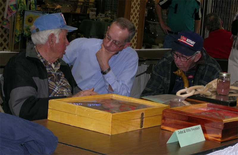 Here the late John (right) and Otto (left) Swennes sit in discussion with Jim Theler at the 2005 MVAC Artifact Show.