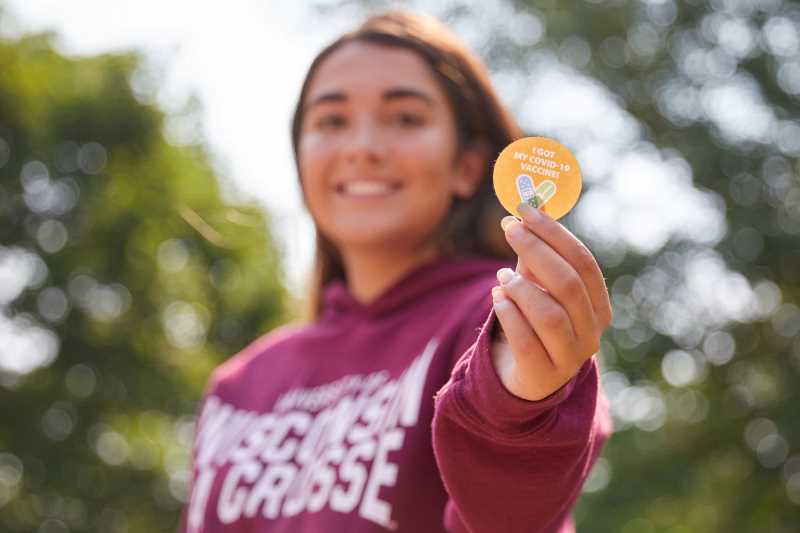  Student holds a sticker reading 