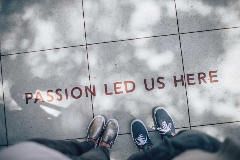 Feet on sidewalk with words: Passion led us here.
