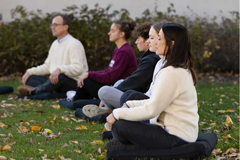UWL Assistant Professor Brian Kumm-Schaley teaches a mindfulness class. Here students sit on cushions in a circle practicing mindfulness on the UW-La Crosse campus.