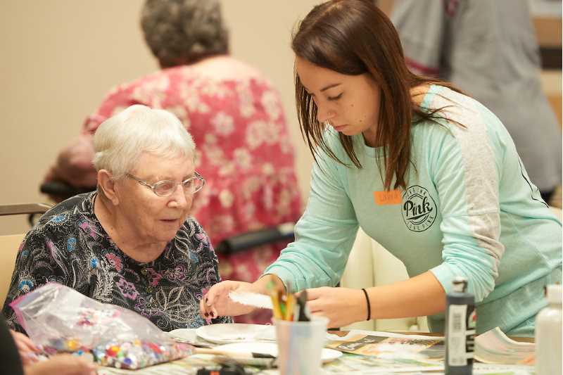 Student working with an elderly woman