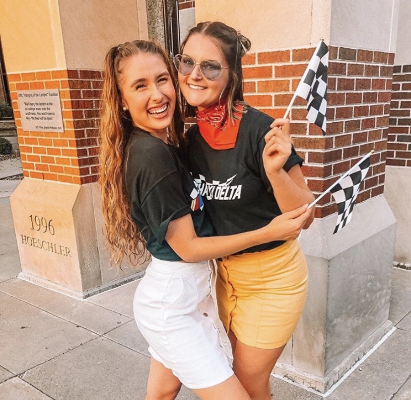 Alpha Xi Delta women pose in their Race-themed bid day outfits.