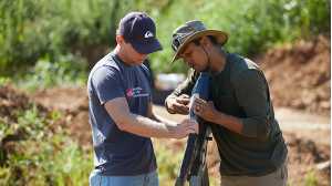 professor and student working with drone in field