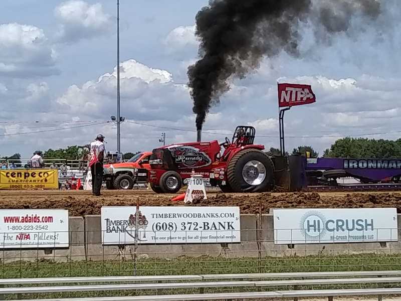 Tractor pulling sled at event.