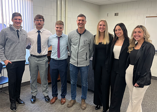 Brian Wroble of Hotel Fortney (center) poses with students following their IMC Plan presentation