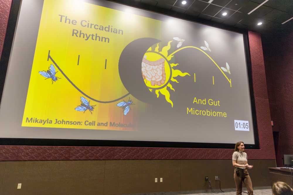 Presentation slide on the circadian rhythm and gut microbiome with a speaker in front.