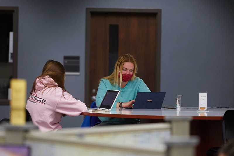 Students studying in Murphy Library wearing masks