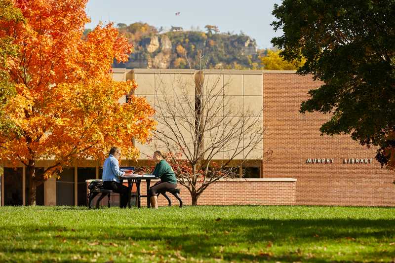 Students sitting at picnic table outside of Murphy Library 