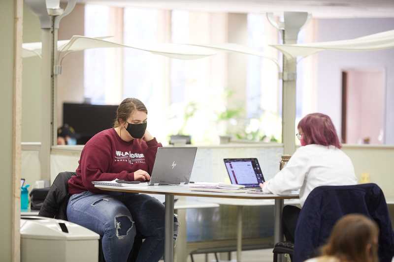 Students studying in Murphy Library wearing masks