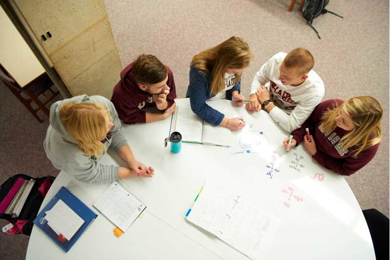 UWL students studying at a whiteboard table in Murphy Library