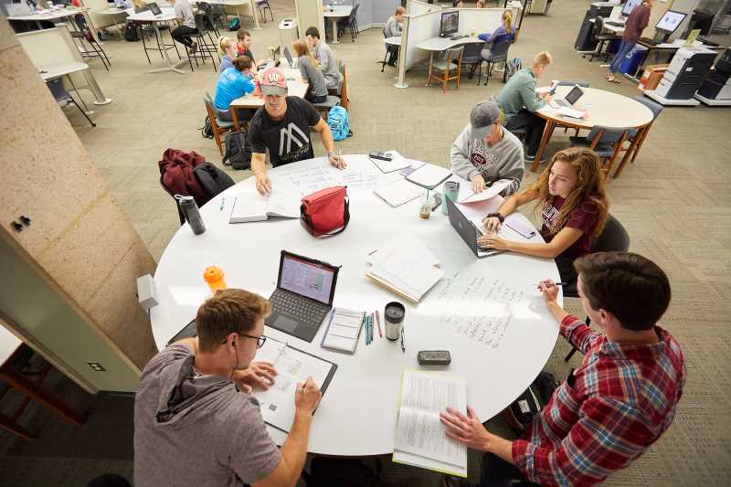 Students studying at one of the whiteboard tables in Murphy Library
