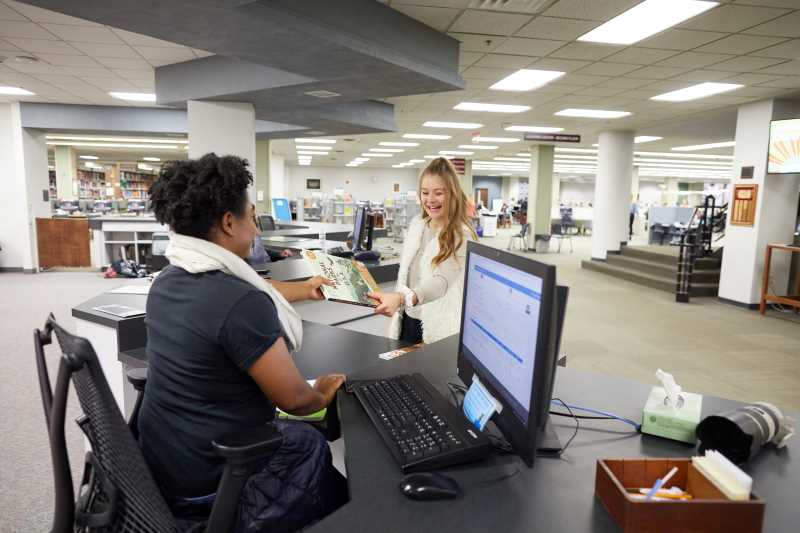 Student checking out book at the Circulation Desk