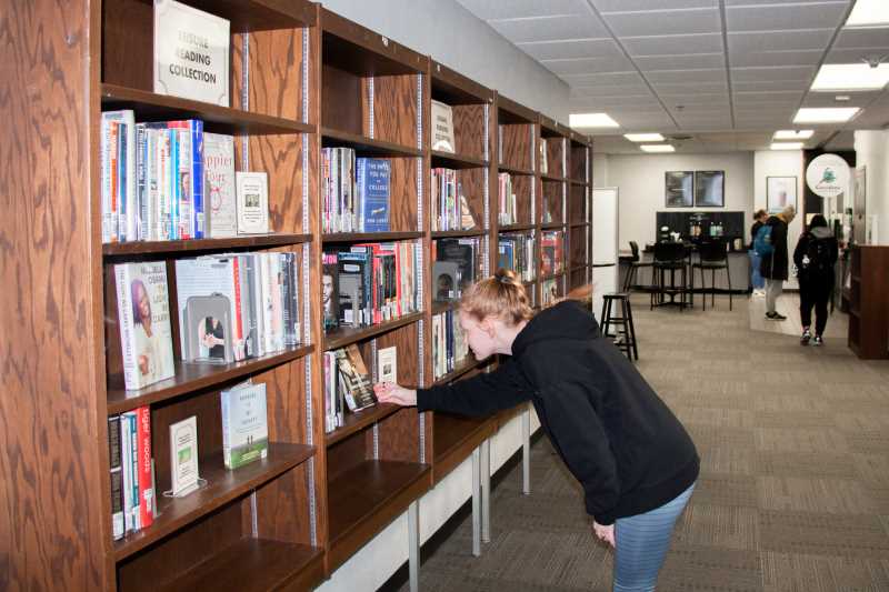 Student browsing books in the Leisure Reading Collection