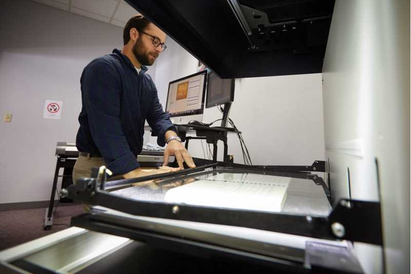 Photo of Digital Collections Librarian David Mindel digitizing materials to add to Murphy Library Digital Collections