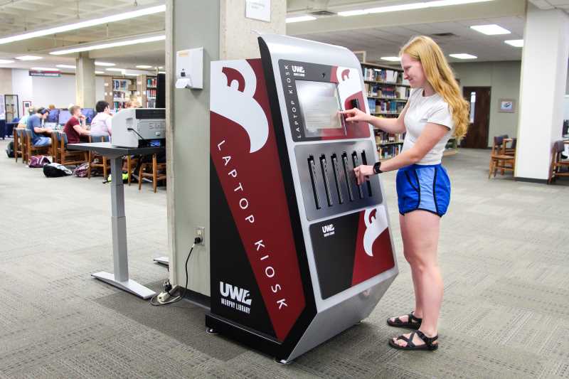 UWL student checking out a laptop from the library's new laptop kiosk