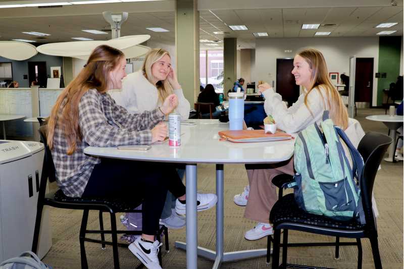 UWL students laughing while studying in Murphy Library