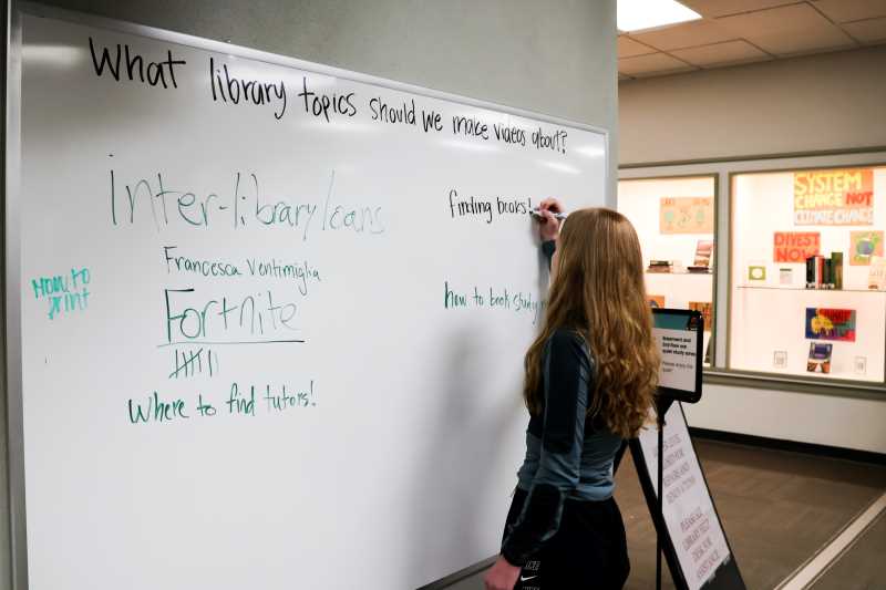 Student writing on the library's 