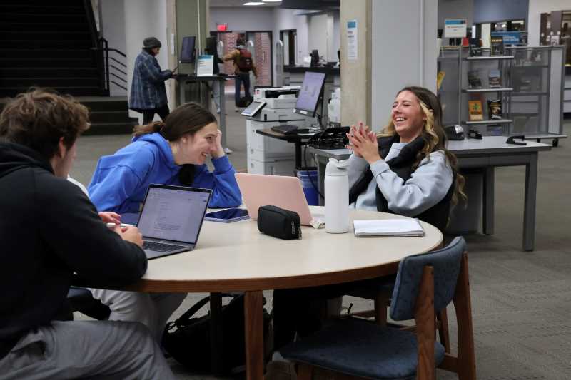 Alt text: Students laughing in Murphy Library