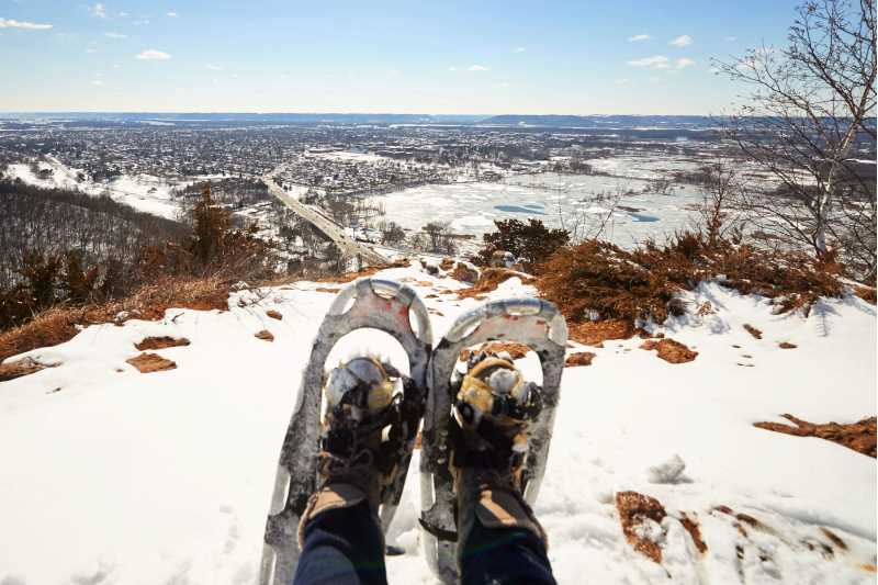 A view from the top of Miller Bluff near the UW-La Crosse campus in winter with snowshoes in the foreground. Enjoying the outdoors is a good temporary way to relax and unwind, but to take care of mental health in the long-term, it is important to practice activities every day that can build a good mental health foundation.