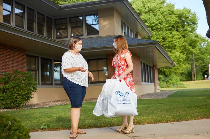 Lisa Klein (right), community engagement coordinator at UWL, receives a donation of homemade masks from Ruth Kinstler of the Coulee Region Senior Volunteer Program. The masks will be available to students and families during UWL's move-in window, Sept. 2-6.