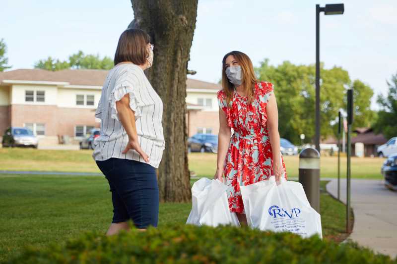 Ruth Kinstler, left, of RSVP hands Lisa Klein, UWL Community Engagement, a donation of homemade masks for students on campus. Move-in will look different this year. Students will return over five days instead of two. And, all students and guests on campus will be required to wear facemasks and abide by physical distancing policies. 