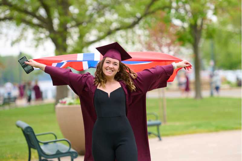 International student Maiken Maeland Vigre celebrates graduation with the flag of Norway.