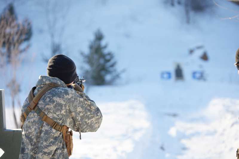A cadet takes aim at a target with an air rifle during the weapons lane challenge at checkpoint three.