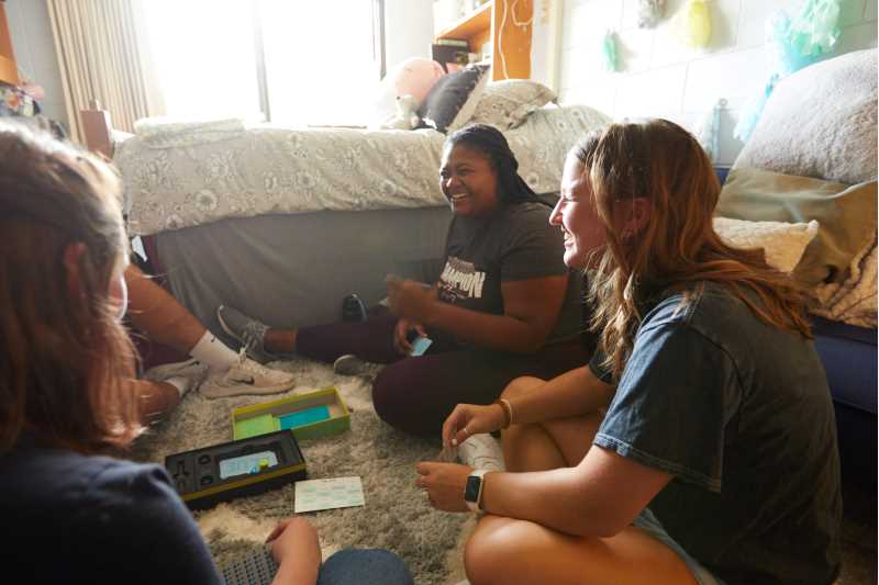 Student play board games in a residence hall room.