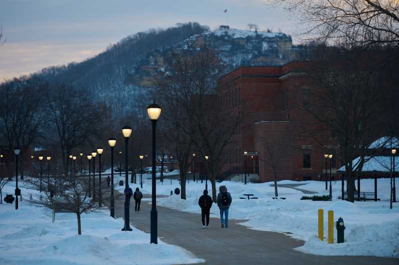 Students walk through campus with Grandad Bluff in the background