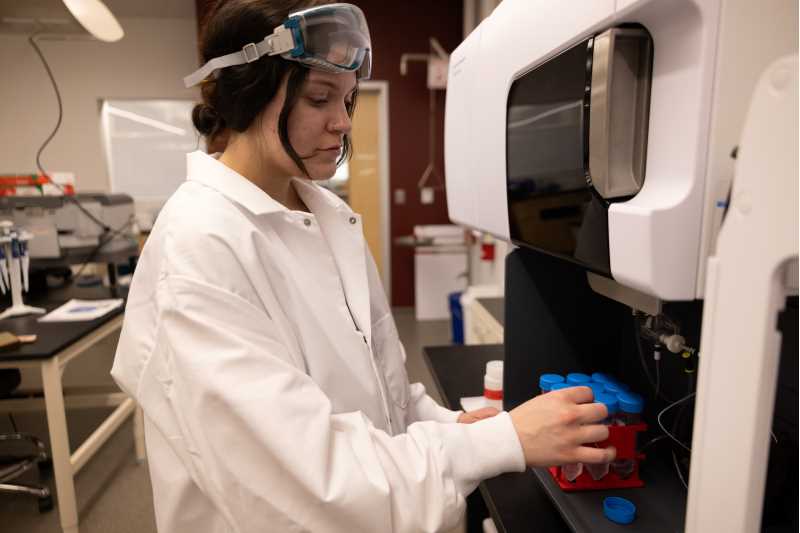 UWL Senior Katie Peterson prepares samples. To simulate entering the stomach, samples of rubber play surface, wood chips and sand are added to  acidic solutions, shaken up and heated at body temperature for two hours, the amount of time the sample would be in someone’s stomach. To simulate a being put in the mouth, a clean water solution is used instead of the acid solution.