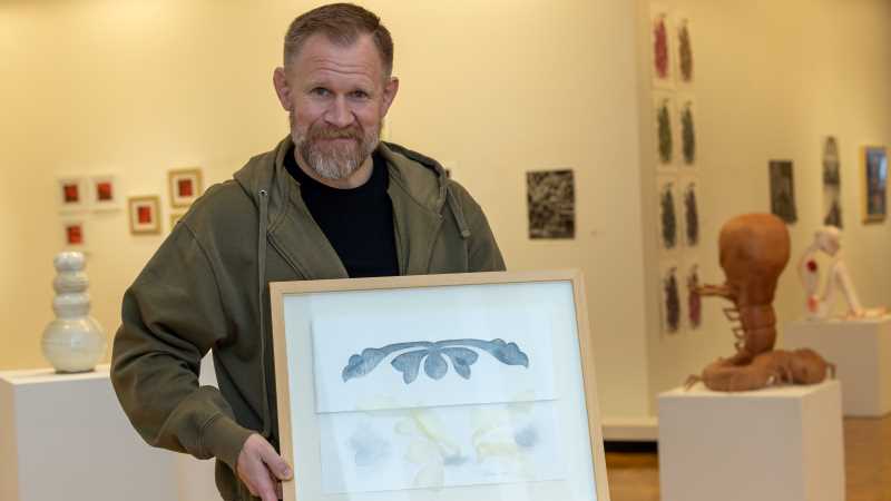 Art Department Chair Brad Nichols shows off  “Synthesis of Pattern IV,” an original piece by UWL alum Truman Lowe. Eric Newhouse, a longtime friend of Lowe, and his wife, Susie, recently donated the piece to UWL. 