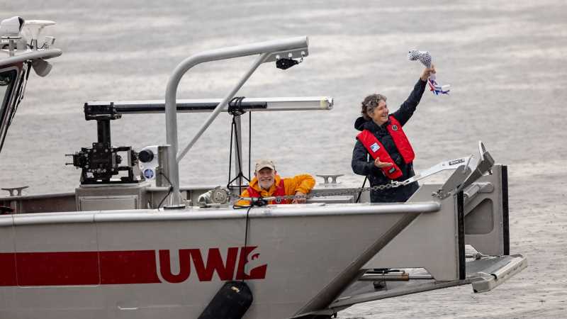 Trustee Carolyn Fleckenstein Scott holds the crushed champagne bottle after christening UWL's new, state-of-the-art watercraft, the Research Vessel Prairie Springs. The $500,000 vessel promises to transform freshwater education at UWL and beyond.