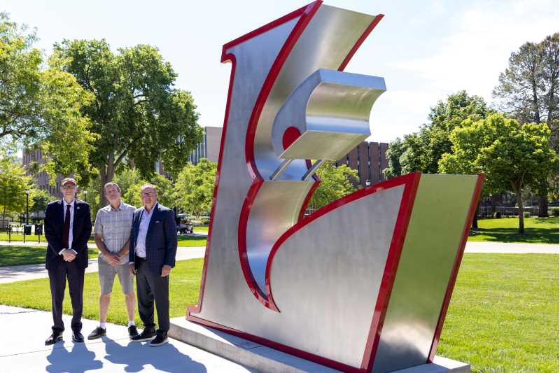 From left, UWL Chancellor James Beeby; artist and alumnus Luke Achterberg, ’04; and alumnus and donor Joe Laux, ’89; pose in front of the new Eagle L sculpture outside the Recreational Eagle Center following the June 23 unveiling. 