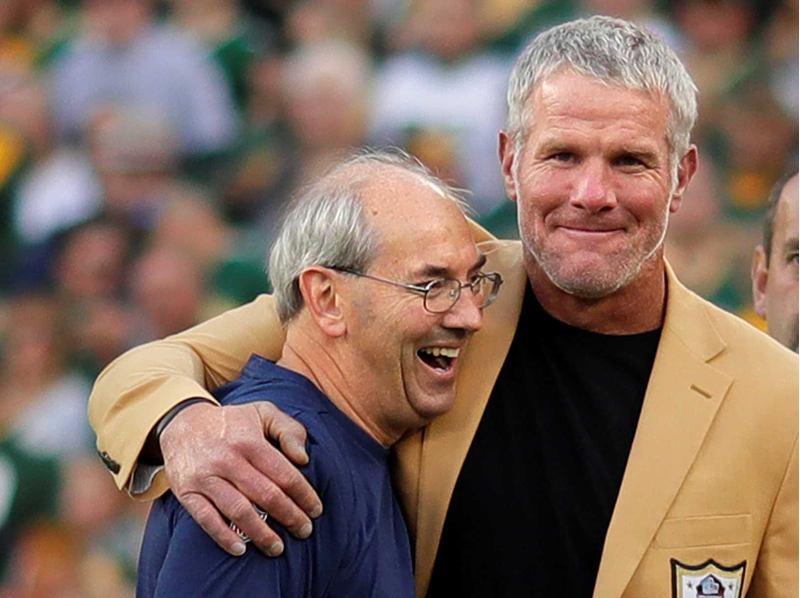 Bryan Nehring, ’83, assistant equipment manager for the Green Bay Packers, gets a hug from former Packers Quarterback Brett Favre