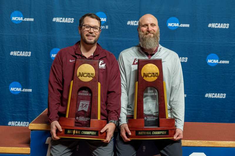 UWL Men’s Indoor Track & Field Head Coach Josh Buchholtz, left, and Women’s Indoor Track & Field Head Coach Nickolas Davis with their team’s national championship trophy.