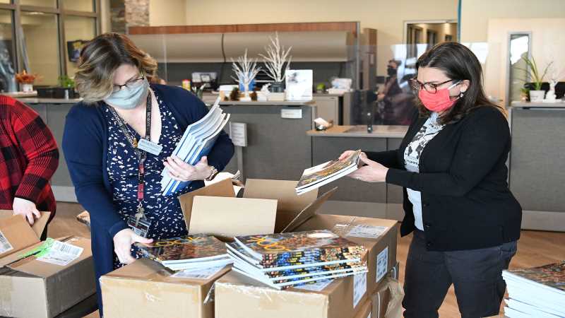 Western's Rebecca Hopkins (left) and UWL's Heather Linville (right) unbox learning materials that will support Afghan evacuees learning English as a Second Language.