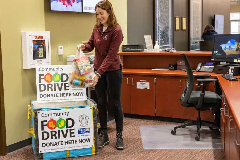 UWL student Chloe Hart deposits a donation during the Great Rivers United Way and Rotary Lights Community Food Drive.