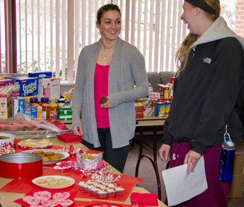 20120214BakeForDrake_DayOfGiving0021w Two students at food tables.