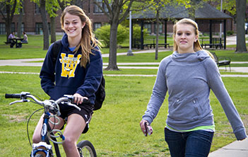 Student on bike and student walking. 
