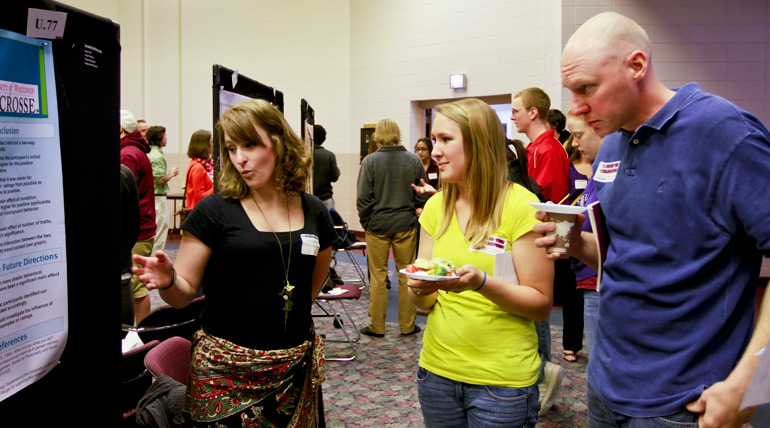 20120414_CelebrationOf_Research_0001ew Photo with student explaining poster to others.