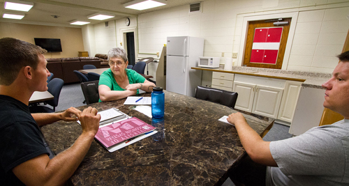 Spencer Niebur, Carol Oyster and Ian Carter at a table in the veterans center.