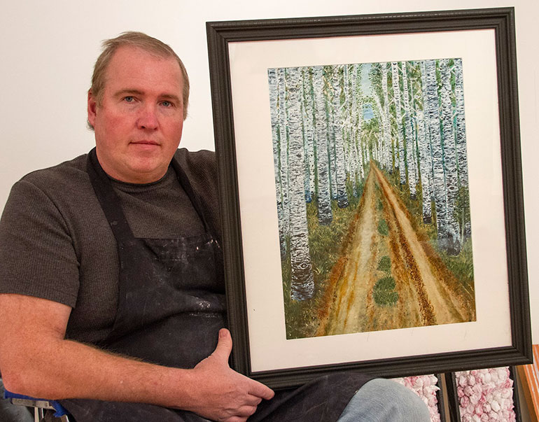 Jim Bennett holding artwork. 