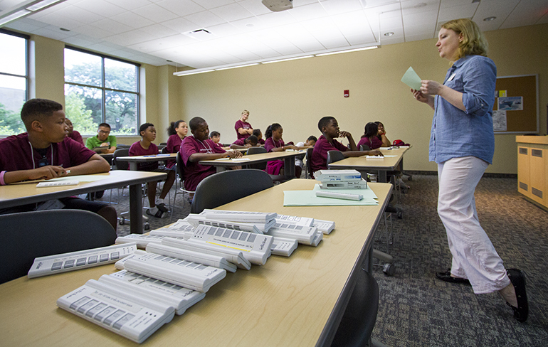 Teacher teaching classroom with clickers in the foreground.